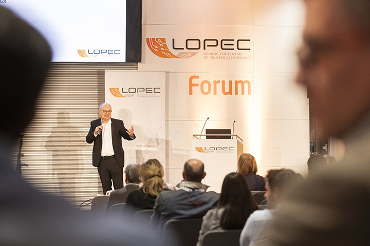 Wolfgang Mildner, General Chair of LOPEC giving the welcome address to the 2,400 attendees of the global flexible, organic and printed electronics industry. Photo courtesy of Messe München