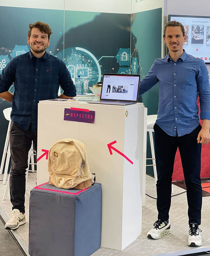 Brakeable Founder/CEO Stefan Hauser (right) and Co-founder/CTO Marc Berli (left) at the Techtextil Frankfurt 2023. In the forefront is the backpack that inspired Inspector by Brakeable®. Photo courtesy Caryn Smith